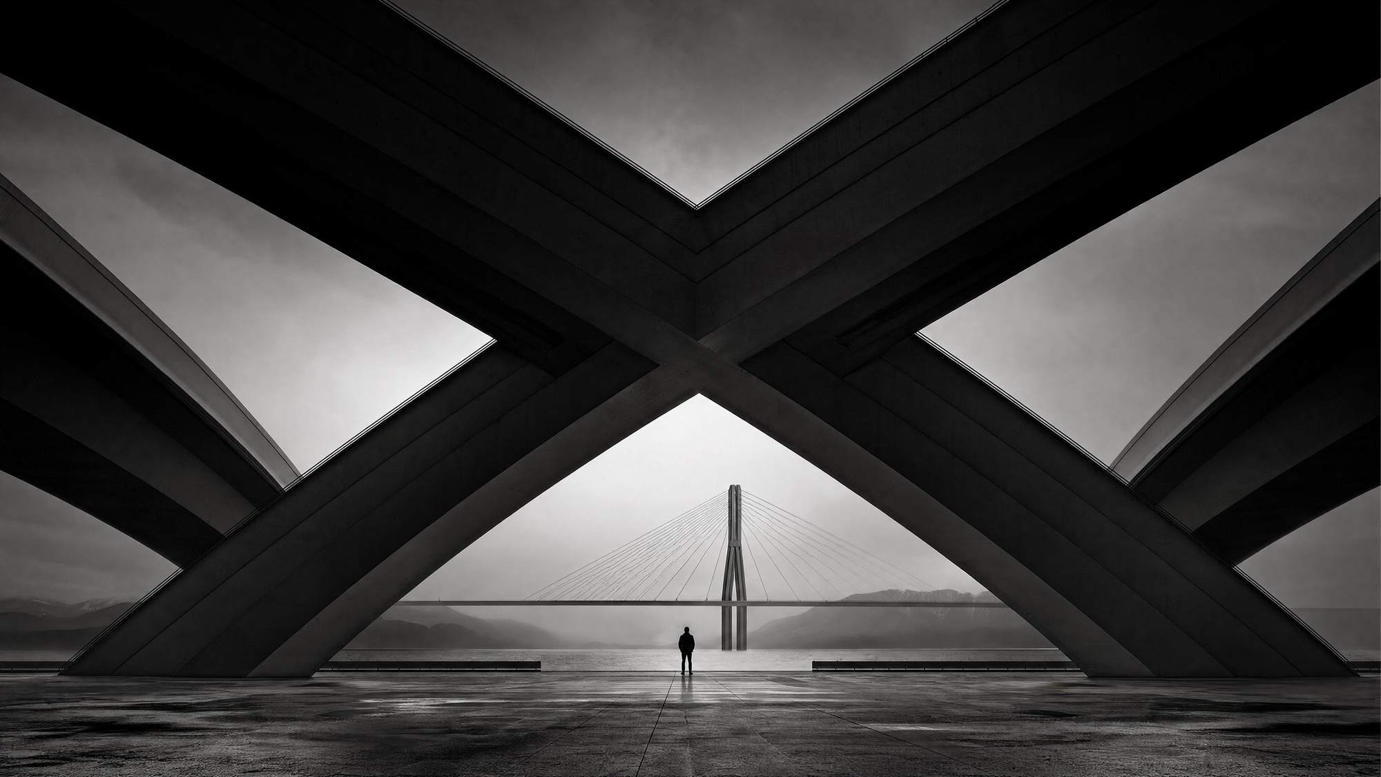 Crossing concrete arches framing a cable-stayed bridge — global trade meeting Abu Dhabi