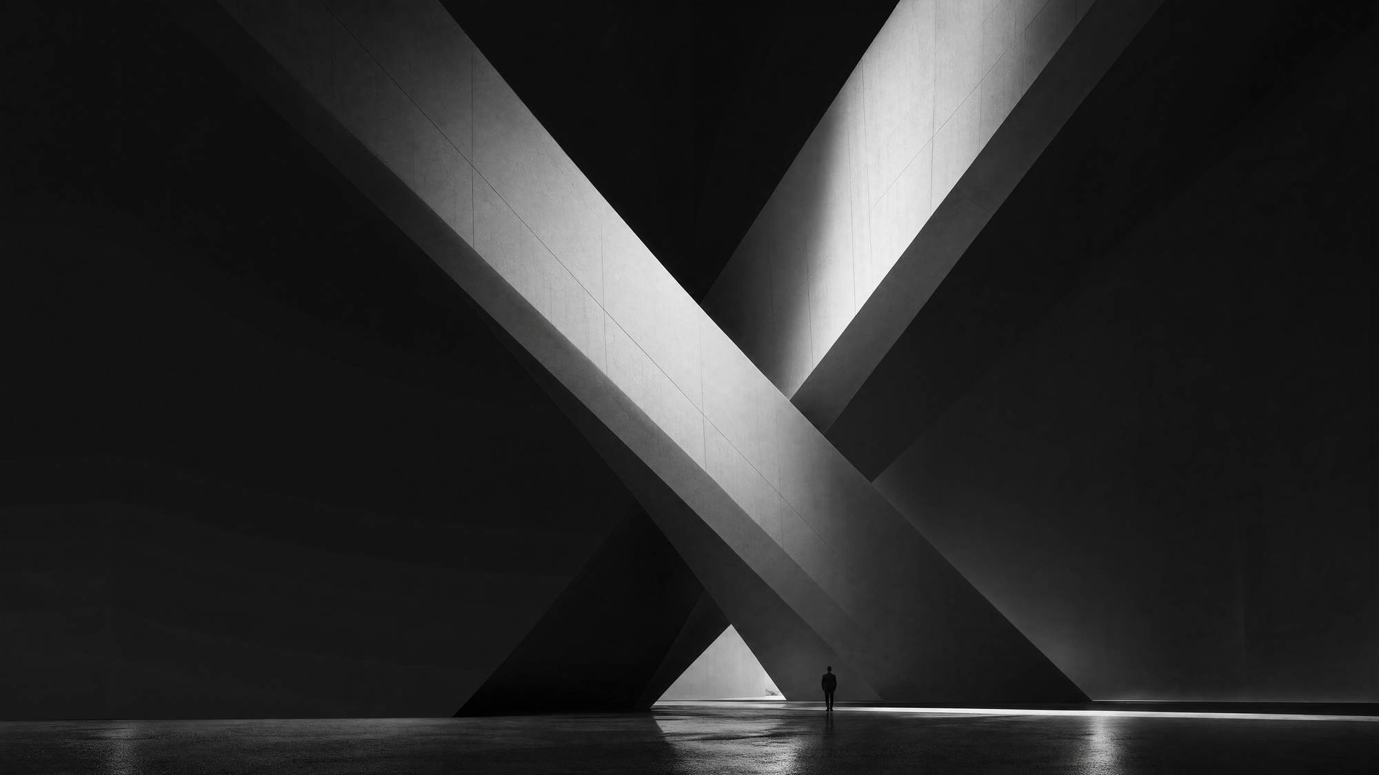 Monumental crossing concrete pillars lit from above — EXG, Abu Dhabi